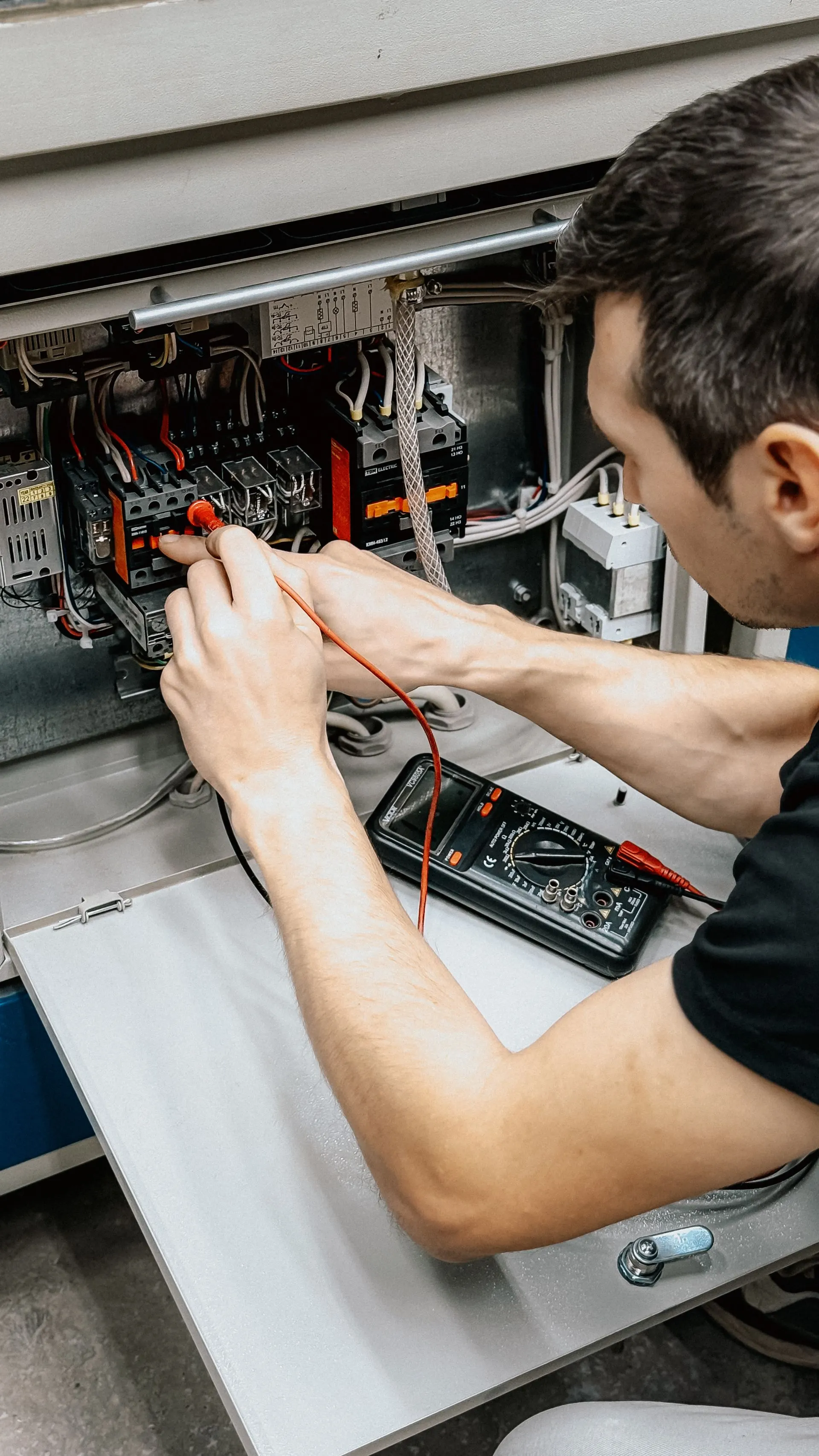 Électricien vérifiant un tableau électrique au multimètre