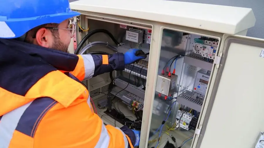 Électricien devant un tableau électrique ouvert